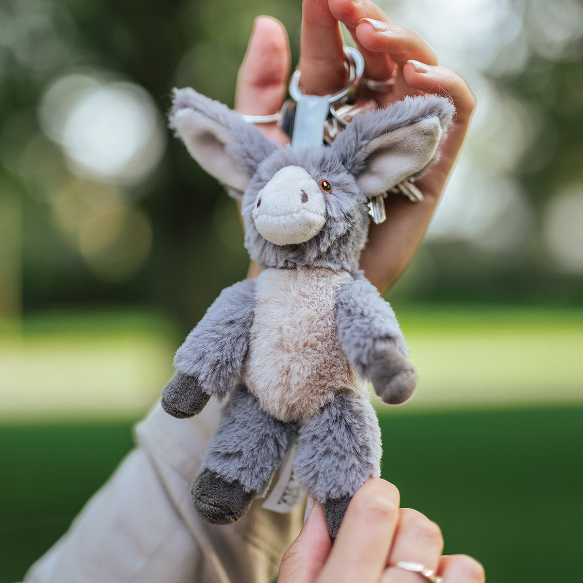 Plüschschlüsselanhänger eines Esel, haltend mit der Hand
