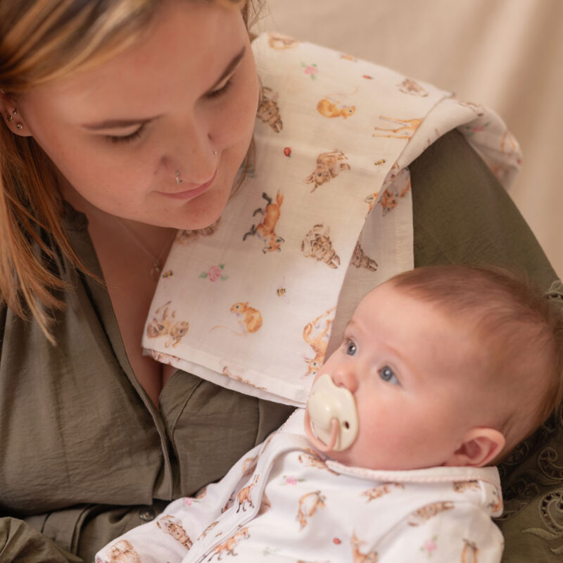 Musselintuch Rosa mit Waldtiermotiven, präsentiert mit einem Baby und seiner Mutter