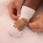 rosa Babysocken mit einem Waldtiermotiv angezogen präsentiert
