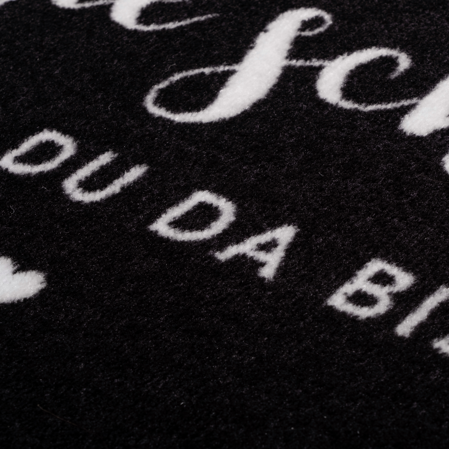 schwarze Fußmatte mit der weißen Aufschrift "Wie schön, dass du da bist"