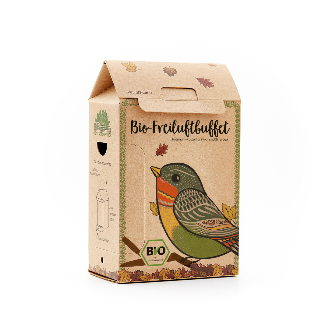 ein hängendes Papphaus mit Holzstand für die Vögel, darin ein Vogelfutter