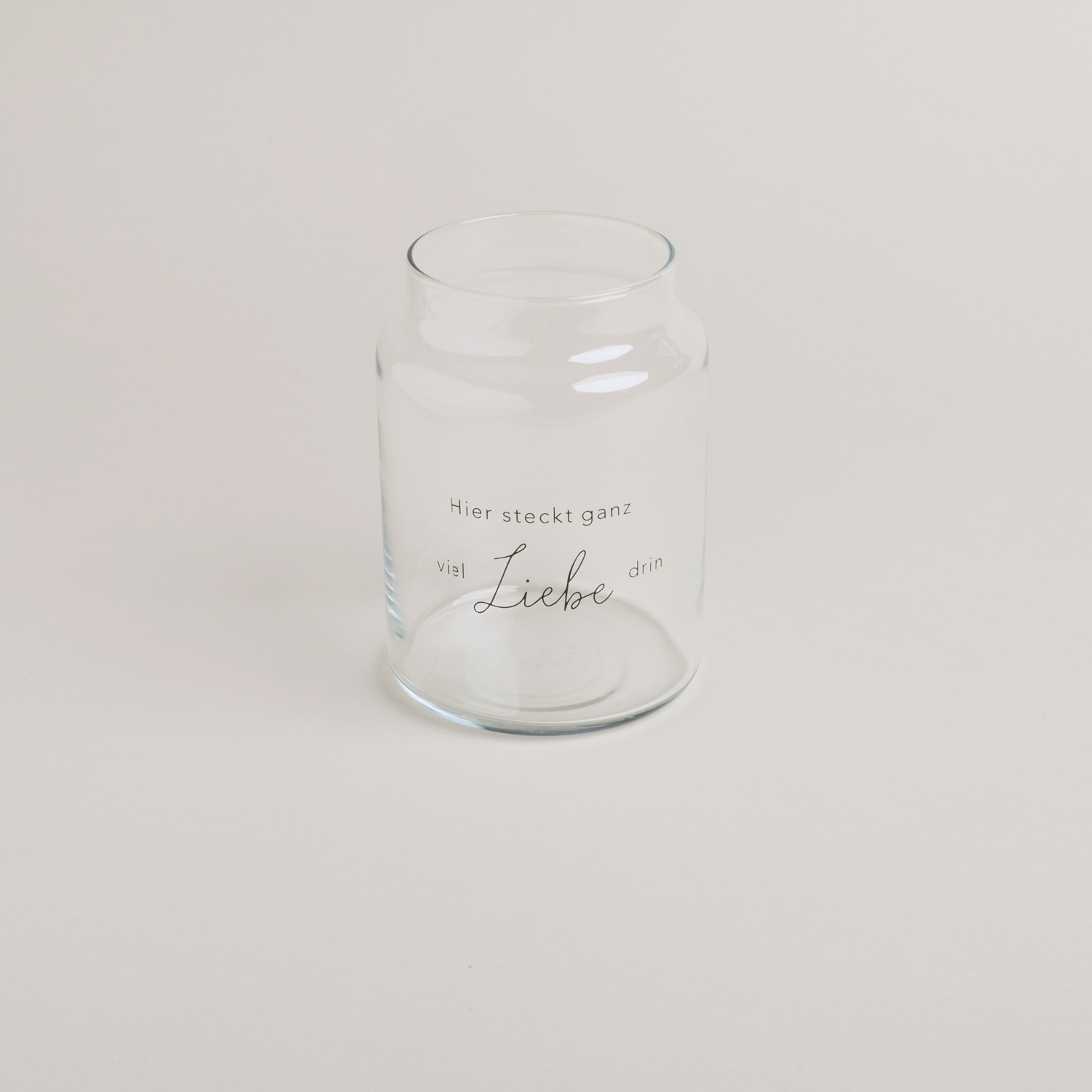 Glasvase mit der schwarzen Aufschrift "Hier steckt ganz viel Liebe drin"