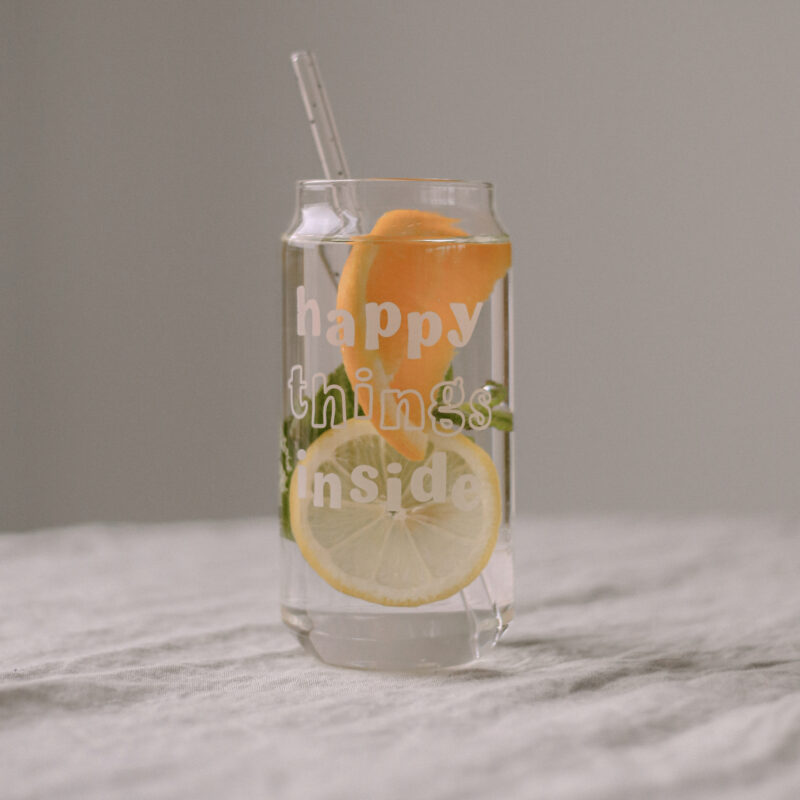 hohes Trinkglas mit der weißen Aufschrift "happy things inside"