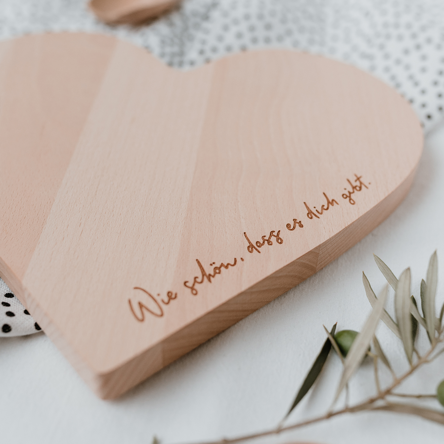 Holzbrett in Herzform mit der Aufschrift "Wie schön, dass es dich gibt"