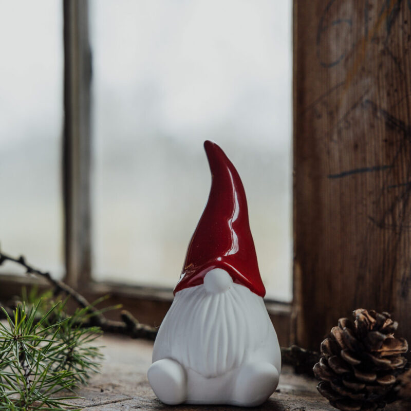 Weihnachtswichtel namens Noel sitzend mit einer roten Zipfelmütze