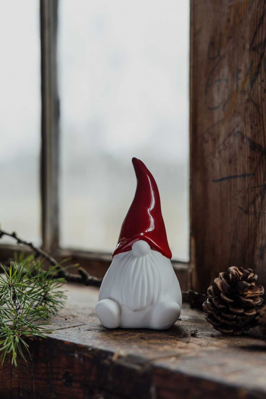 Weihnachtswichtel namens Noel sitzend mit einer roten Zipfelmütze